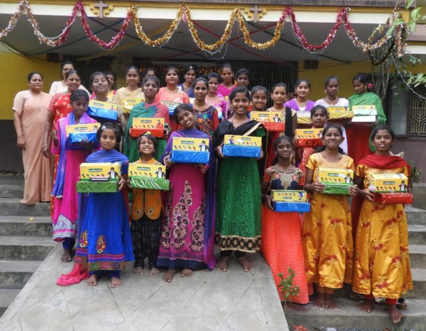 Girls at Karunya Care show their new sandals and wrapped gift
