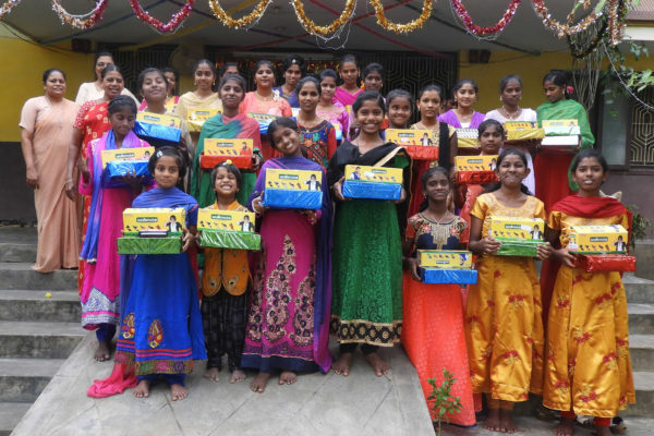 Girls at Karunya Care show their new sandals and wrapped gift.