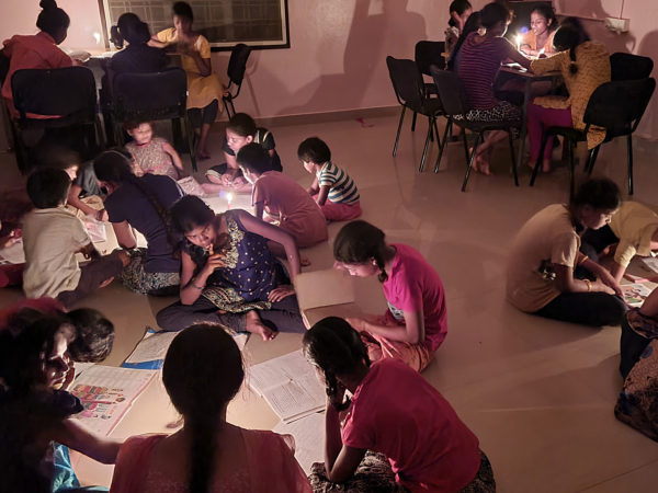Children at Balavikasita study by candlelight when the power is off
