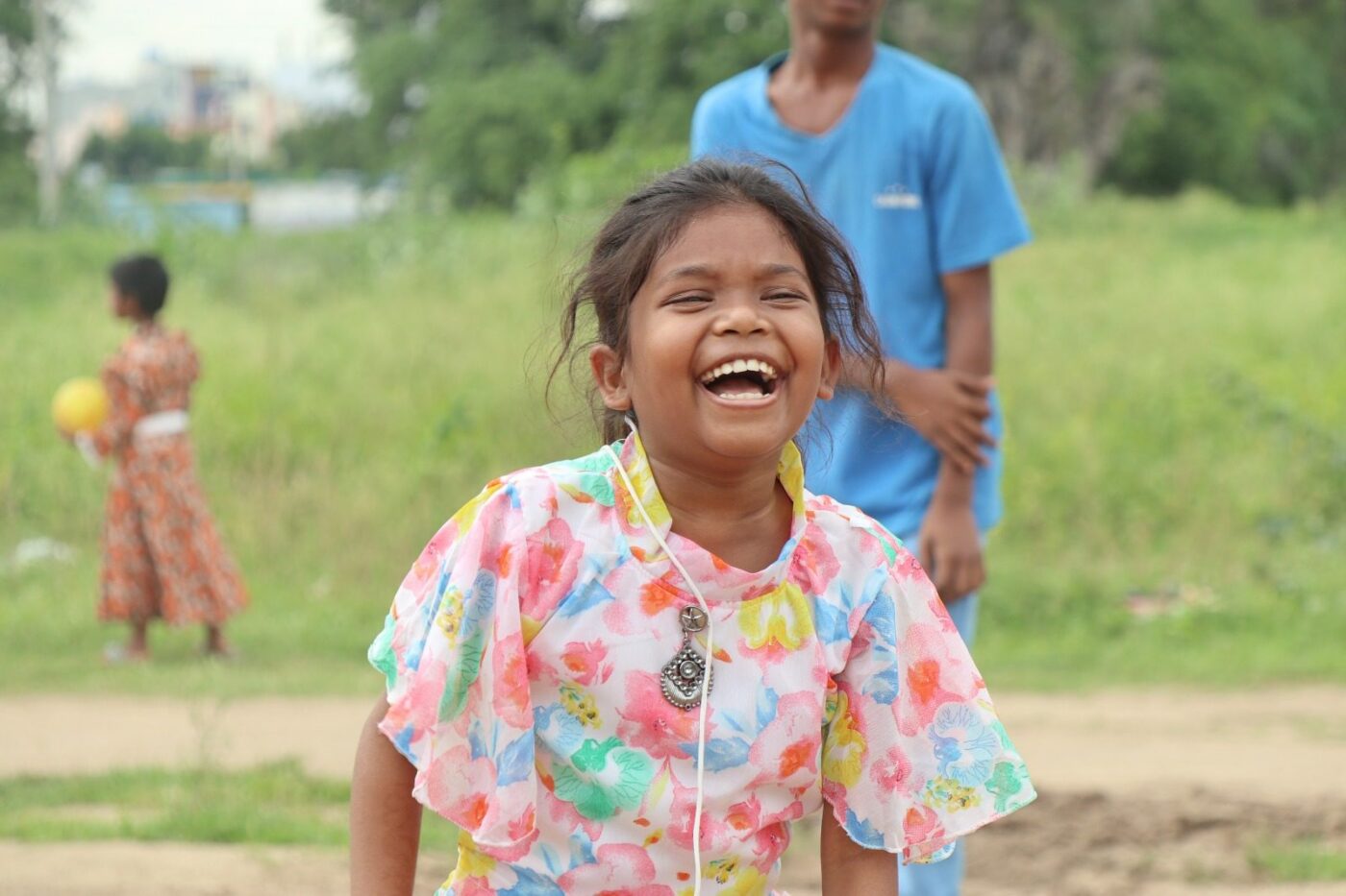 A girl laughing outdoors at a children's home in India